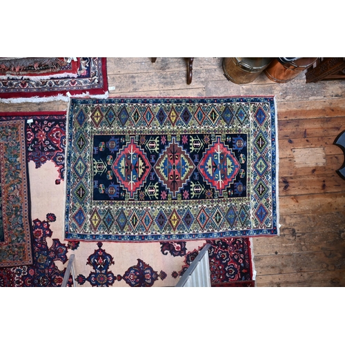 611 - An old Caucasian navy blue ground rug, 184 cm x 125 cm