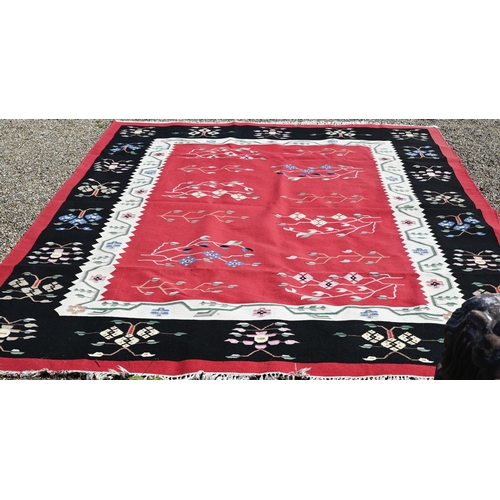 620 - A mid-century Caucasian design Kelim carpet, the stylised floral design on red/black ground, 360 cm ... 