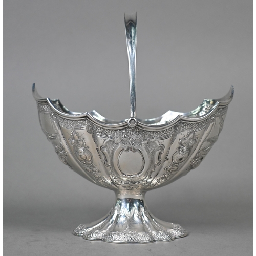 138 - A Victorian silver bonbon basket of lobed navette form with swing handle and embossed and chased dec... 