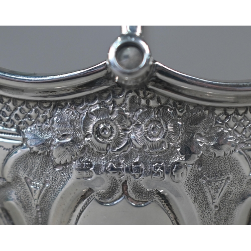 138 - A Victorian silver bonbon basket of lobed navette form with swing handle and embossed and chased dec... 