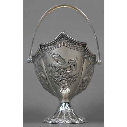 138 - A Victorian silver bonbon basket of lobed navette form with swing handle and embossed and chased dec... 