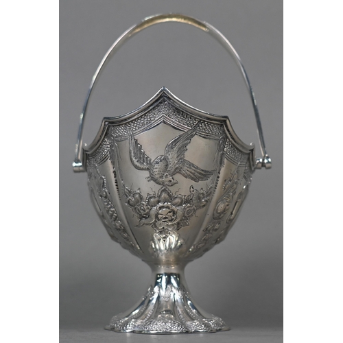 138 - A Victorian silver bonbon basket of lobed navette form with swing handle and embossed and chased dec... 