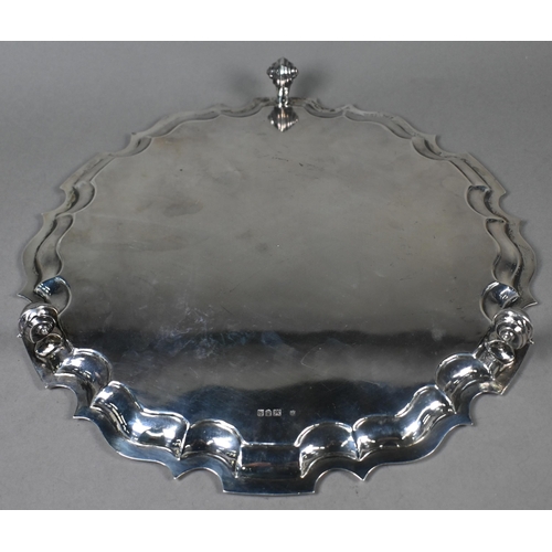 140 - A large silver salver with shaped and moulded rim, on three scroll feet, Thomas Bradbury & Sons ... 