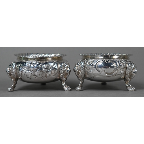 146 - A pair of Victorian silver circular salts with gadrooned rims, floral chased decoration and lion mas... 