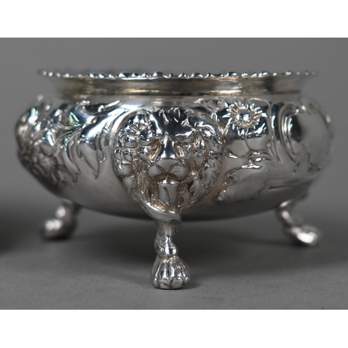 146 - A pair of Victorian silver circular salts with gadrooned rims, floral chased decoration and lion mas... 