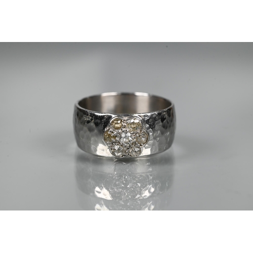 216 - A contemporary 9ct white gold wide band with hammered finish, set with seven-stone diamond cluster, ... 