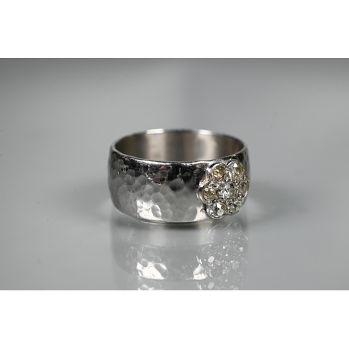 216 - A contemporary 9ct white gold wide band with hammered finish, set with seven-stone diamond cluster, ... 