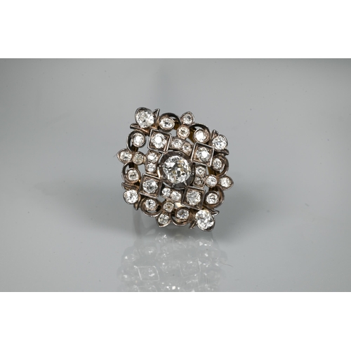 An antique diamond cluster ring, the central old cut diamond sourrounded by a cluster of thirty-two old cut diamonds of various sizes, milgrain set within a silver lozenge design, mounted on a scalloped 9ct yellow gold gallery and tapered shank, approx total carat weight 3.20ct, 2.5 x 2.8 cm overall, approx 12.7g all in, converted from an antique brooch