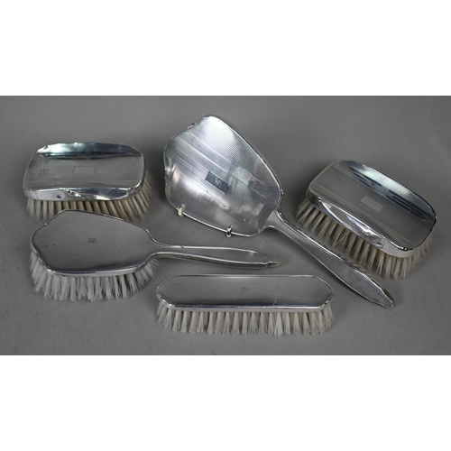 25 - A silver brush set with engine-turned decoration, Birmingham 1949 and a companion pair of hairbrushe... 