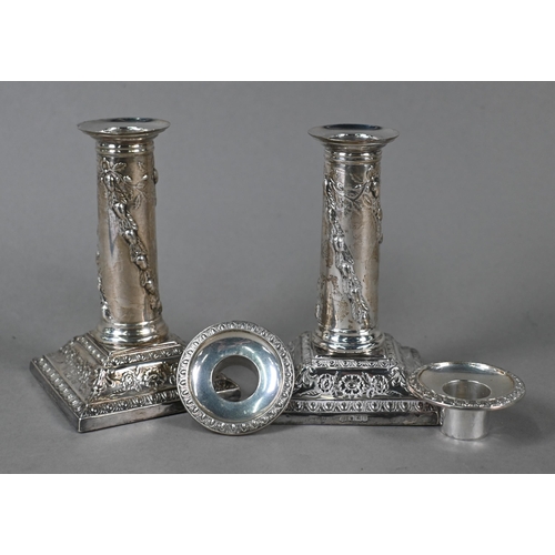 27 - A late Victorian pair of loaded silver candlesticks with embossed pillars and moulded square bases, ... 