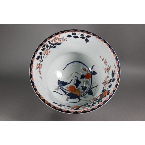 363 - A large 18th century Japanese Arita flared bowl, painted with a continuous design of peonies and pru... 