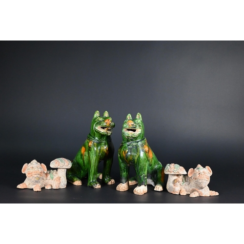 369 - A pair of Chinese Tang style sancai glazed earthenware seated dogs, 19 cm high to/w a pair of Buddhi... 