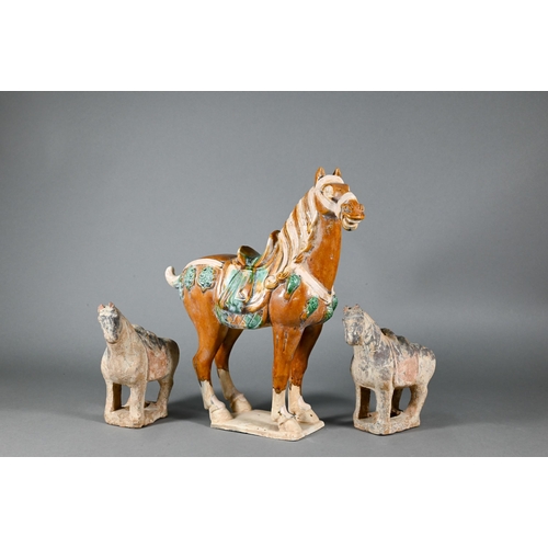 374 - A Chinese Tang style funerary/tomb figure of a horse with sancai glaze, 30 cm high to/w two smaller ... 