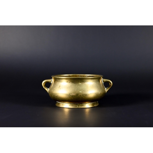 381 - A 19th century Chinese bronze small censer of compressed globular form with looped side handles stan... 