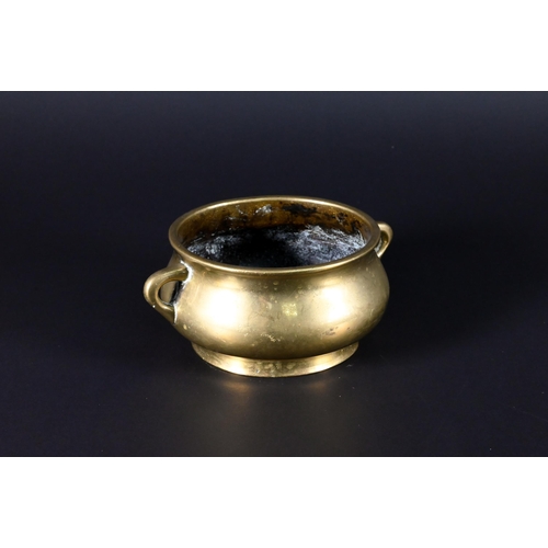 381 - A 19th century Chinese bronze small censer of compressed globular form with looped side handles stan... 