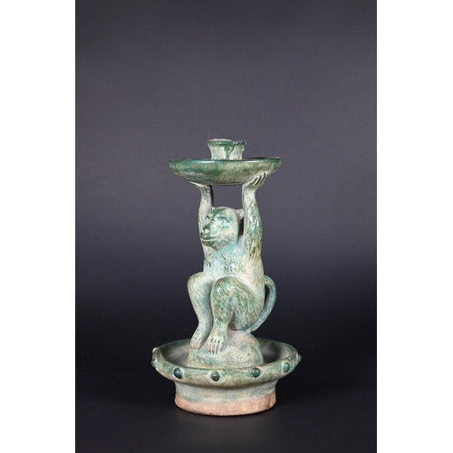 382 - A Chinese green glazed terracotta monkey candlestick with two character signature, 23 cm high