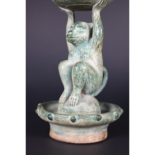 382 - A Chinese green glazed terracotta monkey candlestick with two character signature, 23 cm high