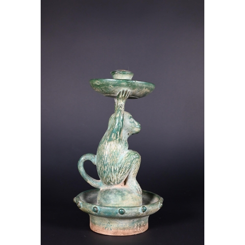 382 - A Chinese green glazed terracotta monkey candlestick with two character signature, 23 cm high