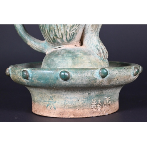 382 - A Chinese green glazed terracotta monkey candlestick with two character signature, 23 cm high