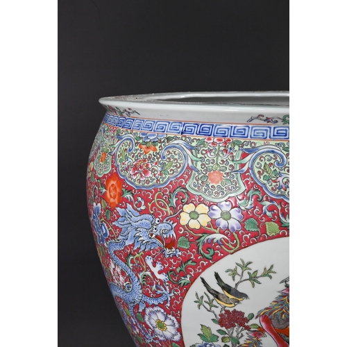 389 - A large Chinese famille rose fish bowl or jardiniere, painted in bright polychrome enamels with thre... 