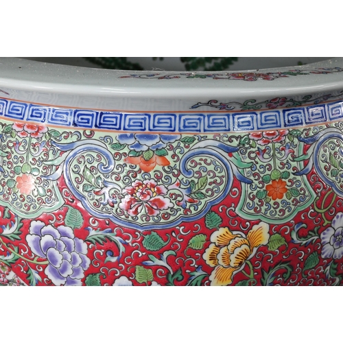 389 - A large Chinese famille rose fish bowl or jardiniere, painted in bright polychrome enamels with thre... 