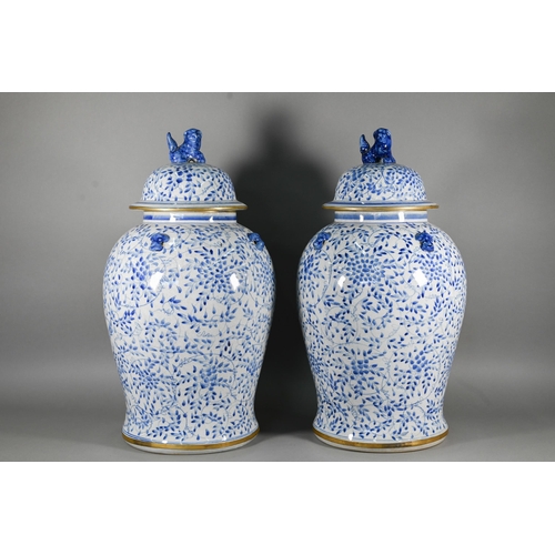 395 - A pair of 20th century Chinese blue and white temple jars and domed covers with karashishi lion fini... 