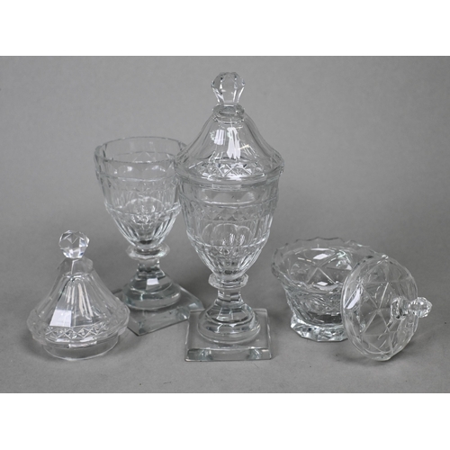 425 - A pair of Regency cut glass covered jars on blade knops and waisted stems to square bases, 18 cm hig... 