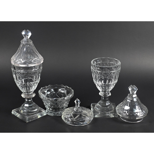 425 - A pair of Regency cut glass covered jars on blade knops and waisted stems to square bases, 18 cm hig... 