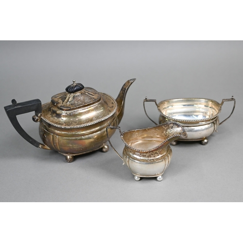 44 - A silver three-piece bachelor tea service with gadrooned rims, composite handle and finial, on ball ... 