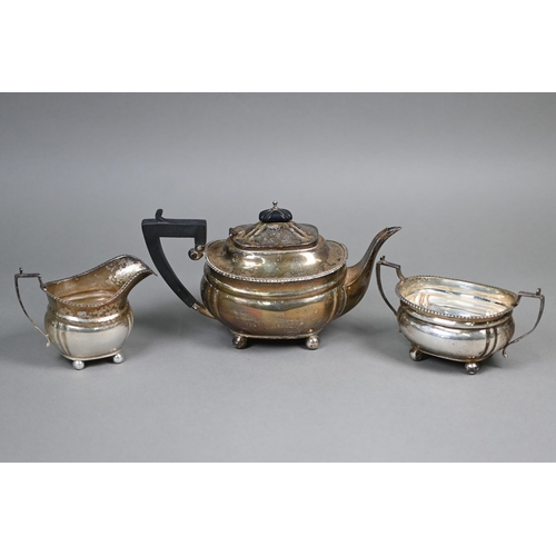 44 - A silver three-piece bachelor tea service with gadrooned rims, composite handle and finial, on ball ... 