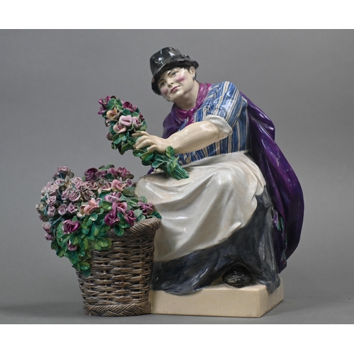 468 - A Charles Vyse Chelsea pottery figure of a flower-seller, seated with her basket of blooms, blue pai... 