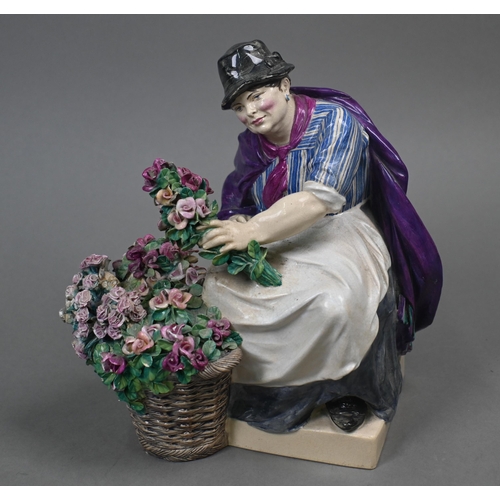 468 - A Charles Vyse Chelsea pottery figure of a flower-seller, seated with her basket of blooms, blue pai... 