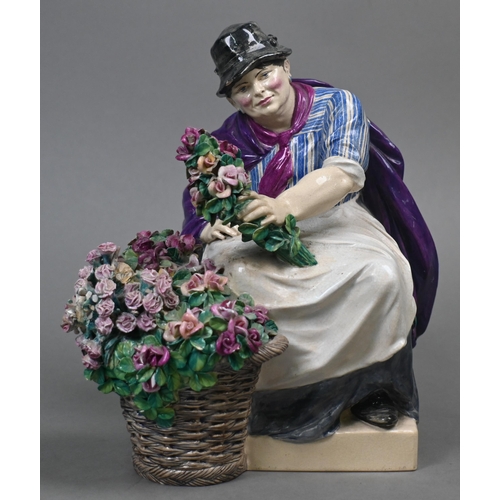 468 - A Charles Vyse Chelsea pottery figure of a flower-seller, seated with her basket of blooms, blue pai... 