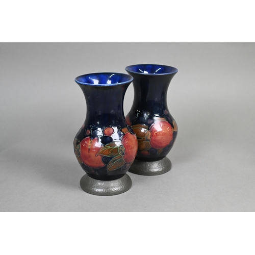 489 - A pair of Moorcroft 'Pomegranate' blue-ground baluster vases with hammered pewter bases stamped 'A. ... 