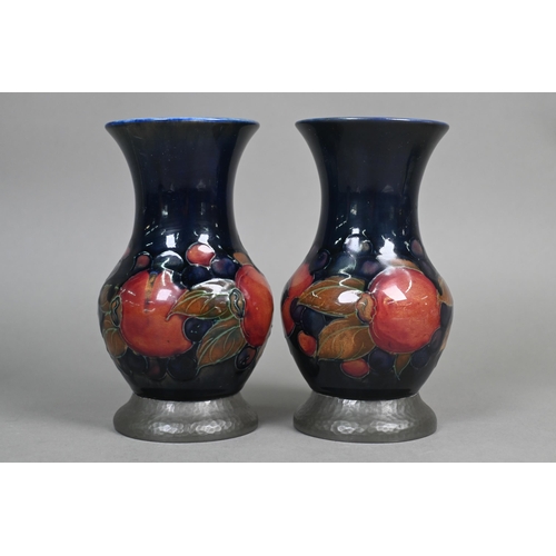 489 - A pair of Moorcroft 'Pomegranate' blue-ground baluster vases with hammered pewter bases stamped 'A. ... 