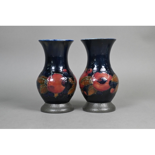 489 - A pair of Moorcroft 'Pomegranate' blue-ground baluster vases with hammered pewter bases stamped 'A. ... 