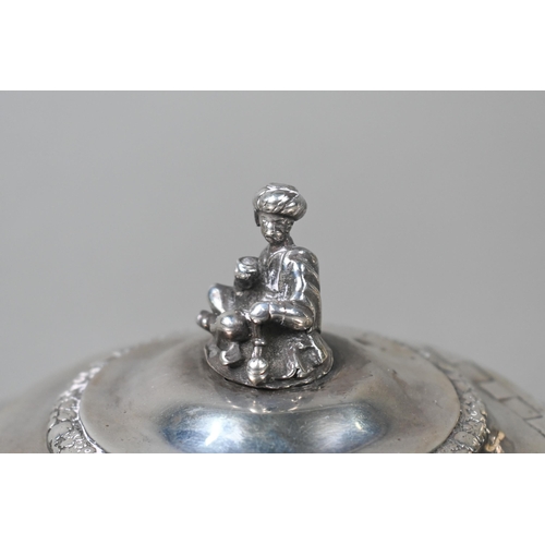 55 - A George IV silver teapot in the Regency taste, the finial cast as a seated Eastern figure, above ch... 