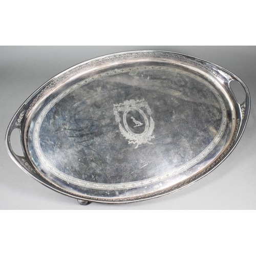 6 - A large Edwardian Regency Revival epns oval tray with pierced rim and engraved decoration, on bun fe... 