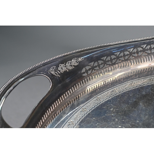 6 - A large Edwardian Regency Revival epns oval tray with pierced rim and engraved decoration, on bun fe... 