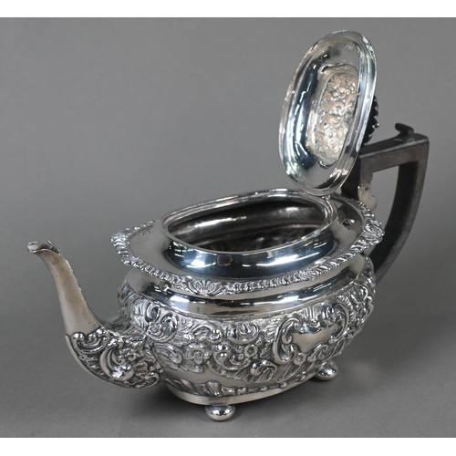 63 - An Edwardian silver four-piece tea service including kettle on stand, with embossed and chased decor... 