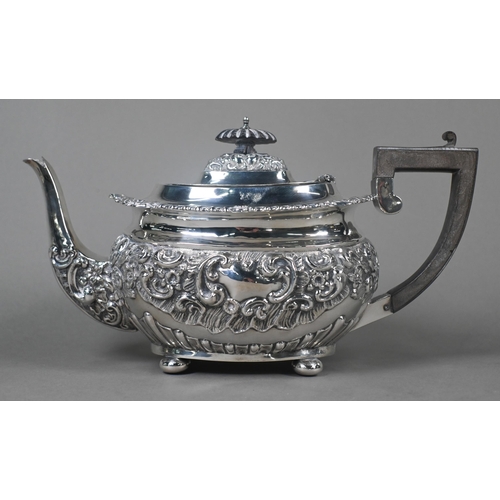 63 - An Edwardian silver four-piece tea service including kettle on stand, with embossed and chased decor... 