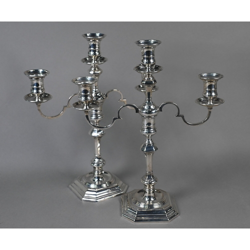 78 - A pair of loaded silver twin-branch candelabra with three sconces and detachable tops, on octagonal ... 