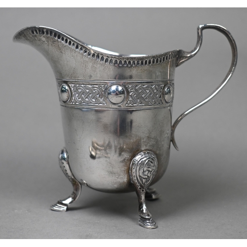 86 - An Irish silver cream jug with Celtic strapwork frieze and hoof feet, Dublin 1914, to/w four pairs o... 