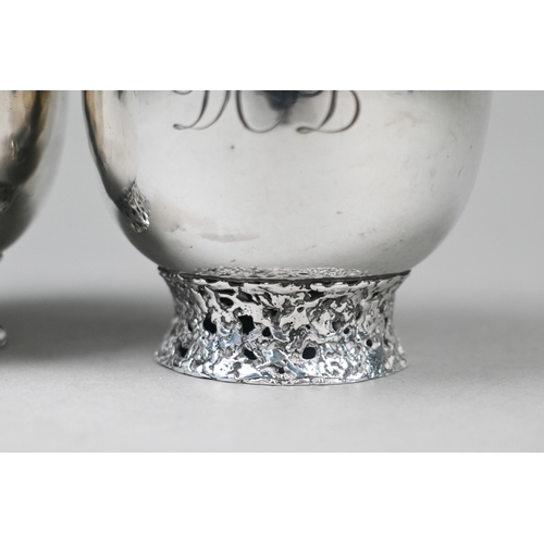 94 - John Donald (1928-2023). A scarce pair of bespoke silver cups, each raised on pierced and textured r... 