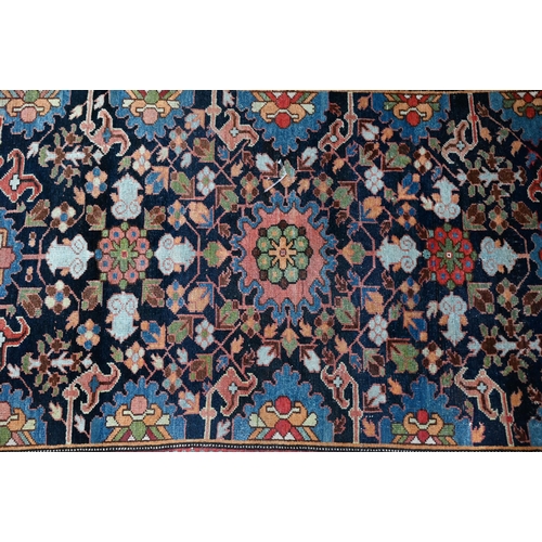 601 - An antique Caucasian blue ground rug, with geometric floral design, 144 cm x 115 cm