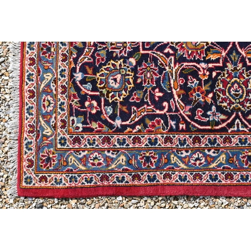 605 - A Persian Kashan carpet, mid 20th century, the traditional centre floral medallion on crimson ground... 