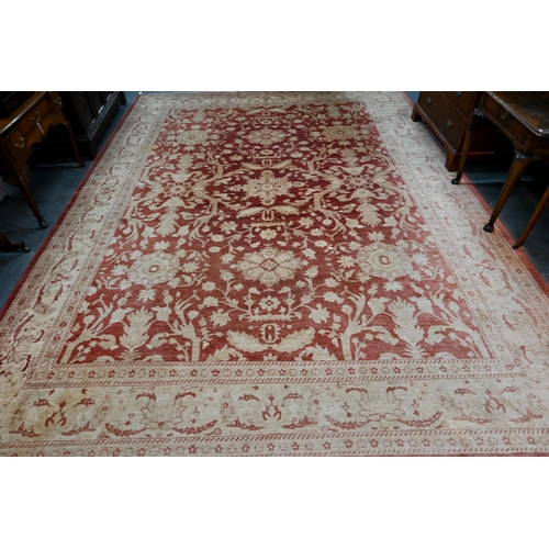 608 - A contemporary Agra carpet, the pale coral ground with repeating floral designs in pale yellow-gold,... 