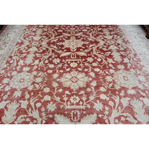 608 - A contemporary Agra carpet, the pale coral ground with repeating floral designs in pale yellow-gold,... 