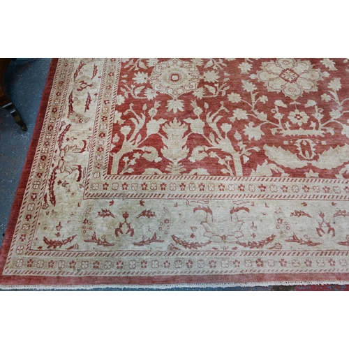 608 - A contemporary Agra carpet, the pale coral ground with repeating floral designs in pale yellow-gold,... 