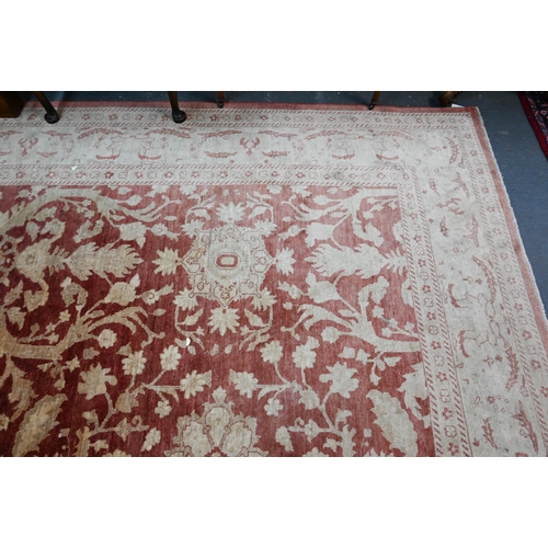 608 - A contemporary Agra carpet, the pale coral ground with repeating floral designs in pale yellow-gold,... 